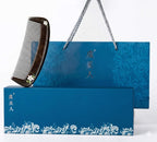 Black comb on a blue decorative box with floral patterns