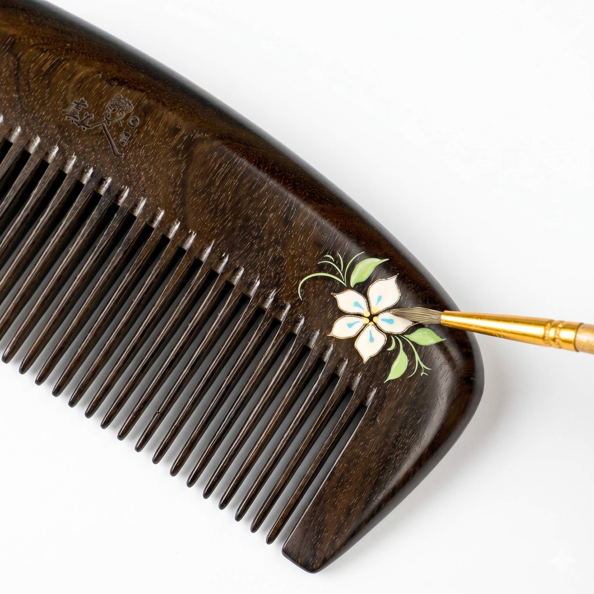 Wooden comb with floral design on a white background