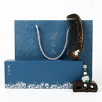 Traditional Chinese hair comb and decorative item on a blue box with floral patterns.