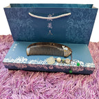 Decorative comb with decorative box on a pink textured surface