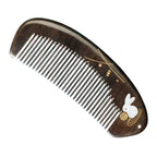 Wooden comb with a rabbit design on a white background