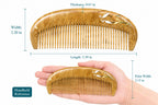 Wooden comb with measurements and a hand holding it for scale on a white background