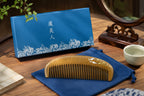 Wooden comb on a blue cloth with a blue pouch and white cup in the background