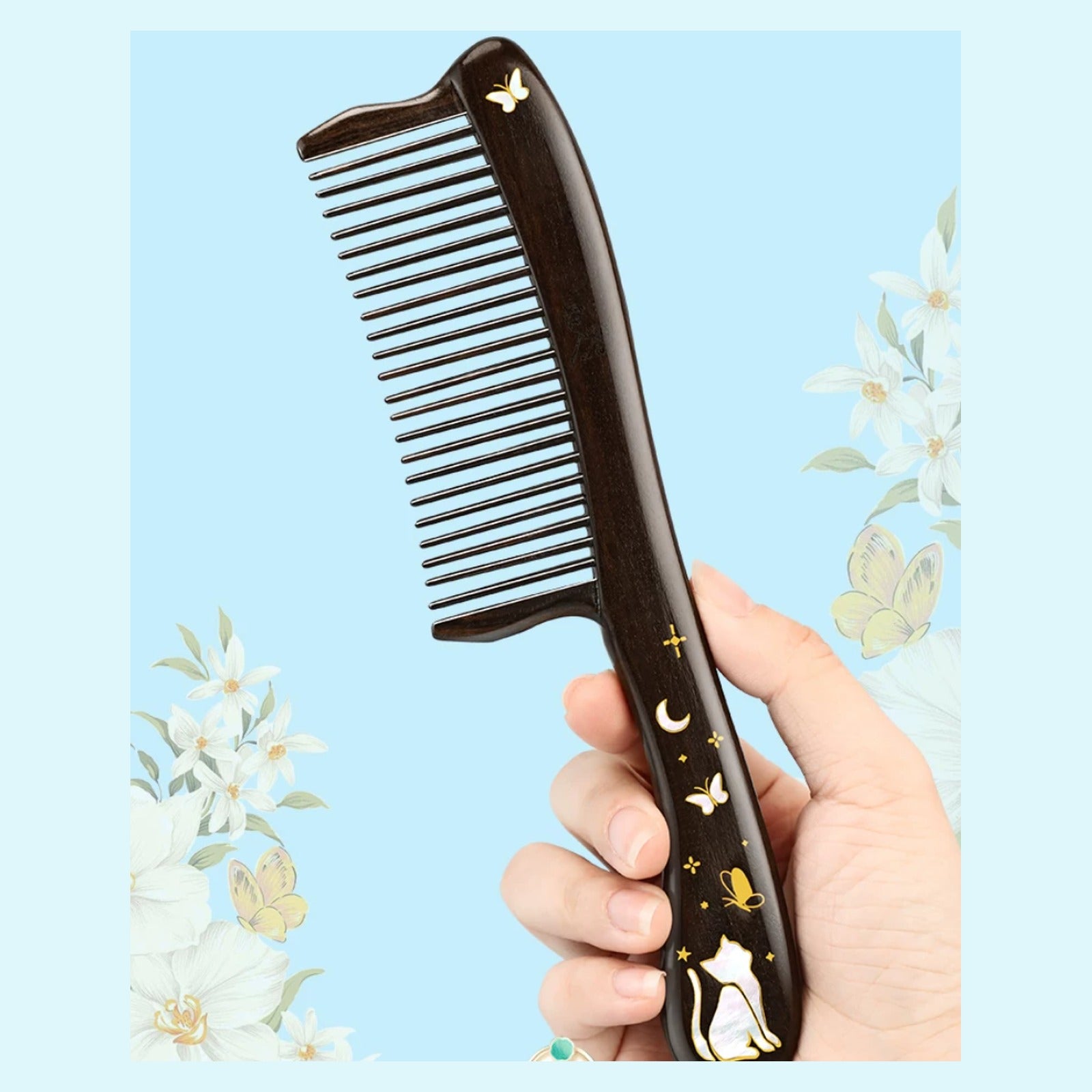 Handheld black ebony wood comb with rounded handle and cat motif
