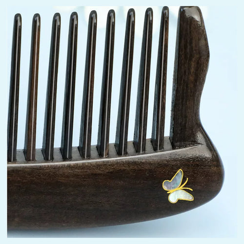 Close-up of durable rounded teeth on a black ebony wood comb
