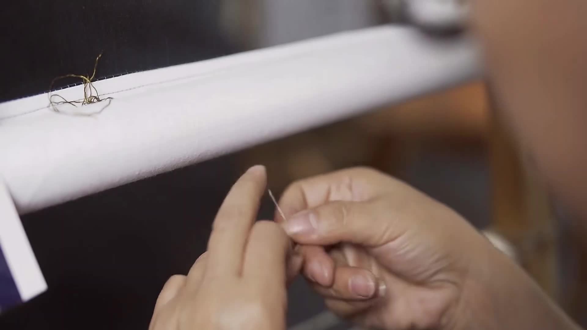 Close-up of an artisan preparing silk thread and needle for Changzhou Random Stitch Embroidery, a Chinese intangible cultural heritage craft