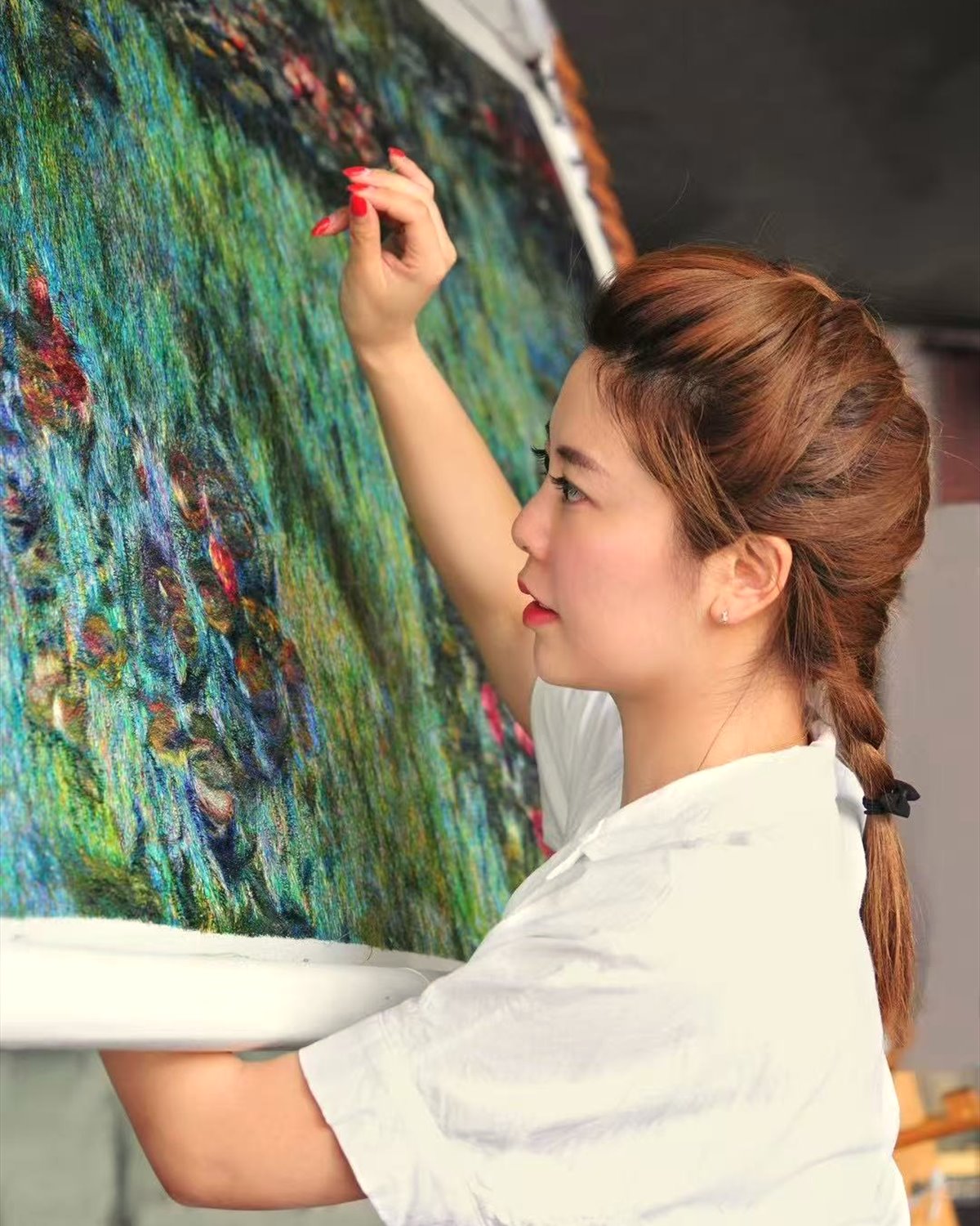Chinese artisan creating a colorful Changzhou Random Stitch Embroidery artwork by hand